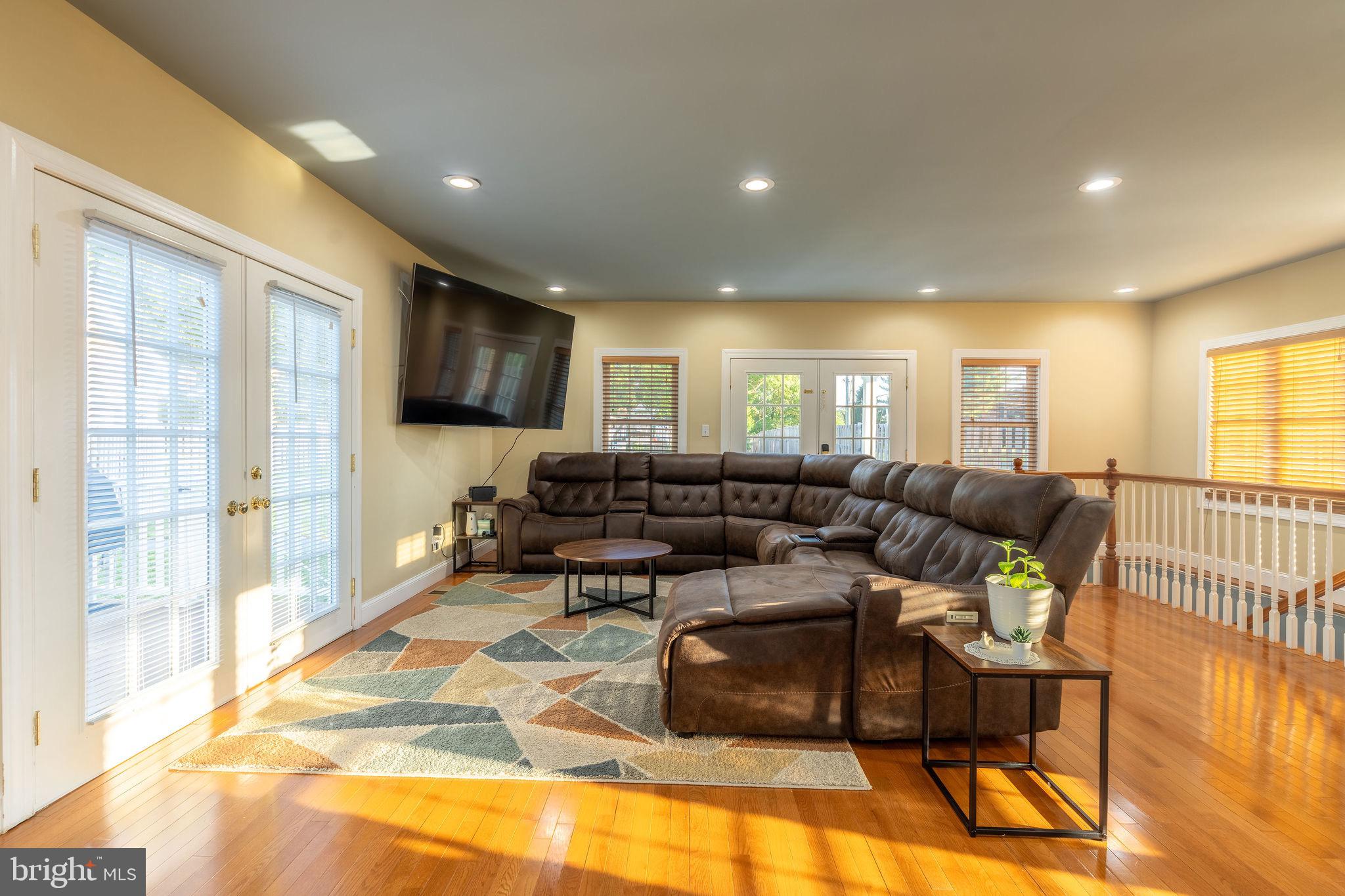 25325 Woodfield Road Damascus, MD 20872 - Photo 16 of 58 a living room with furniture and a table with wooden floor