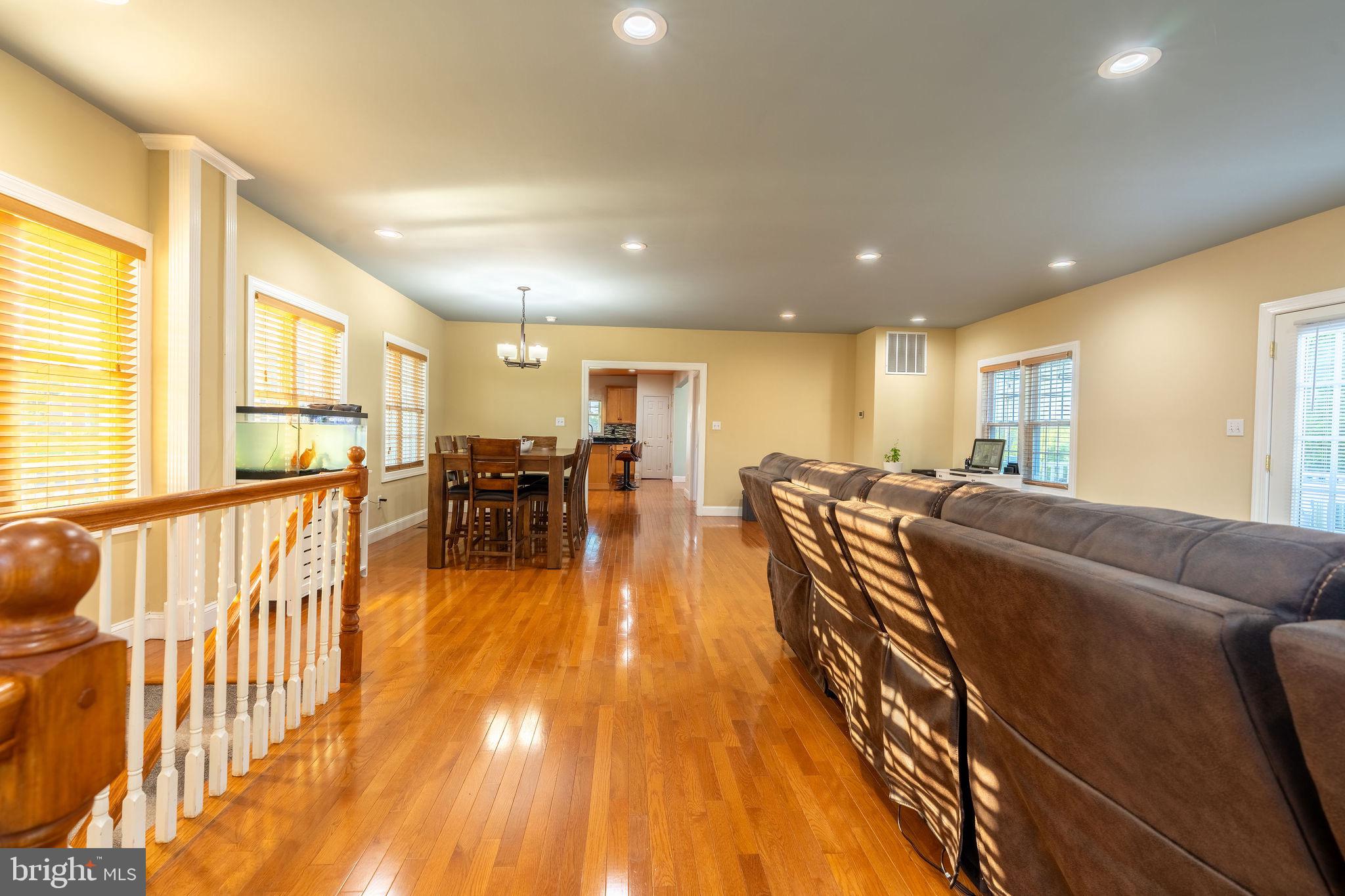 25325 Woodfield Road Damascus, MD 20872 - Photo 18 of 58 a living room with furniture and a dining table with wooden floor