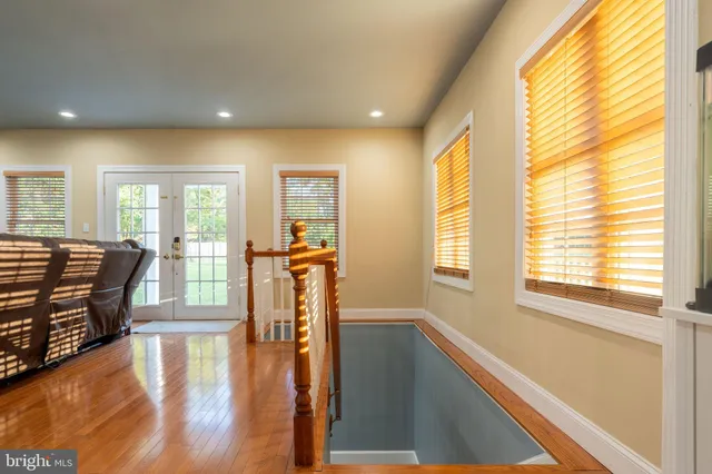 a living room with furniture a wooden floor and a large window