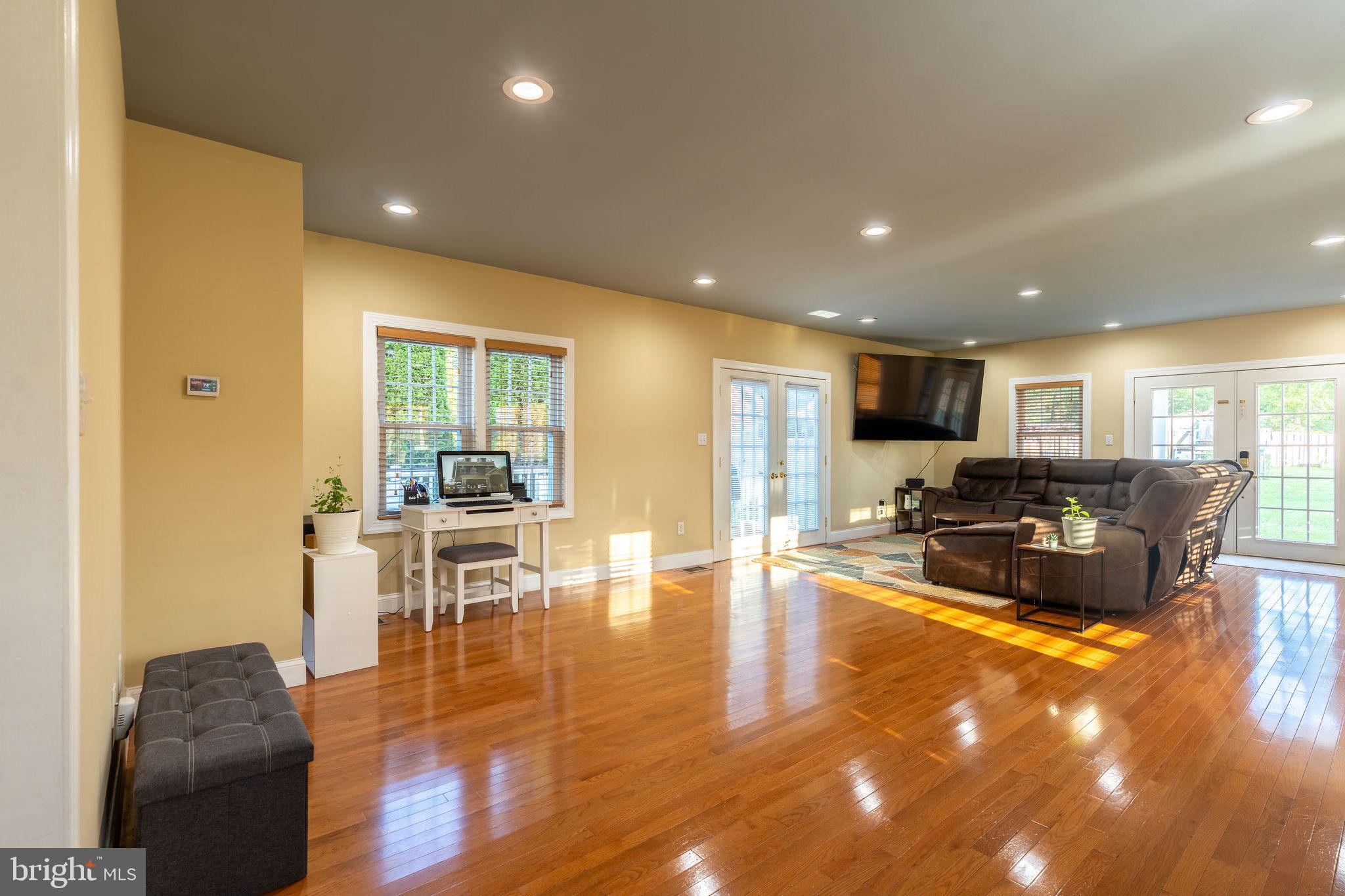 25325 Woodfield Road Damascus, MD 20872 - Photo 20 of 58 a living room with furniture a wooden floor and a large window