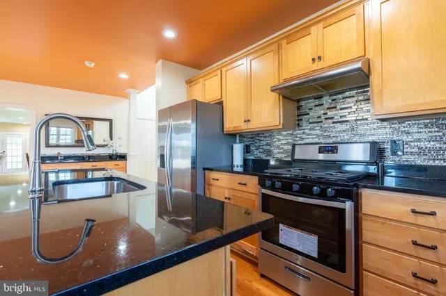 a kitchen with kitchen island granite countertop a sink appliances cabinets and a counter top space
