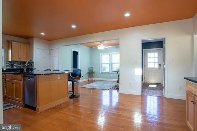 a kitchen with stainless steel appliances granite countertop a refrigerator a stove and a sink with wooden floor