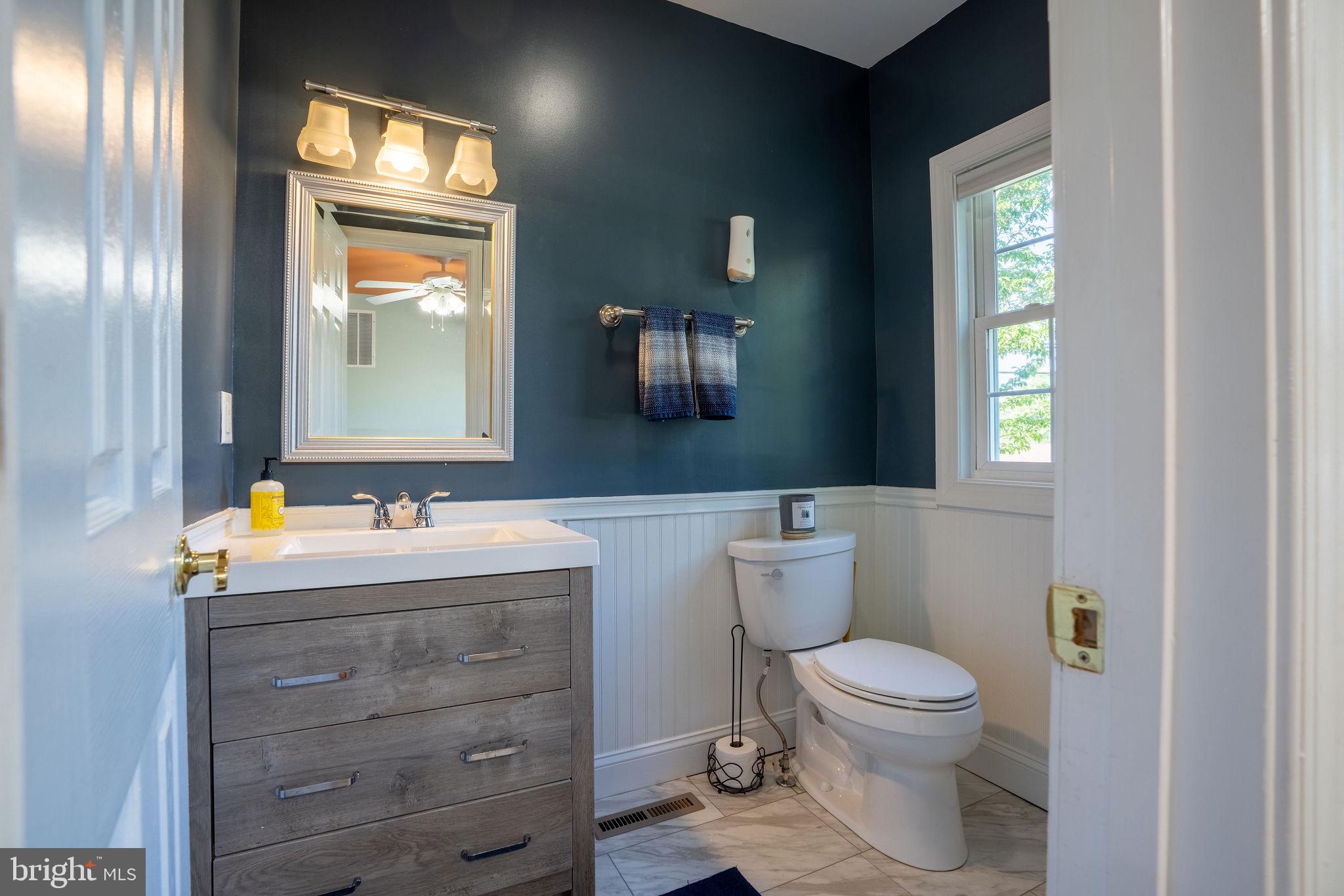 25325 Woodfield Road Damascus, MD 20872 - Photo 36 of 58 a bathroom with a toilet sink and mirror