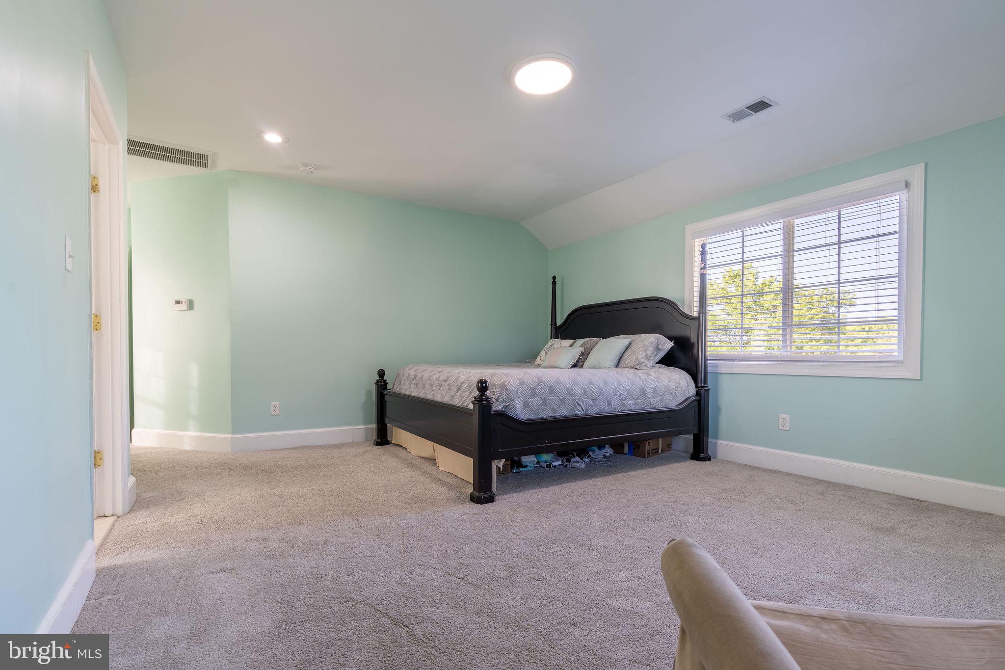 25325 Woodfield Road Damascus, MD 20872 - Photo 39 of 58 a spacious bedroom with a bed and a window