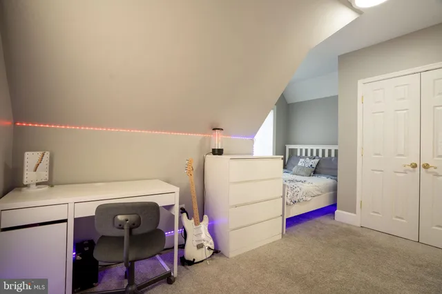 a view of a hallway with wooden floor and a bathroom