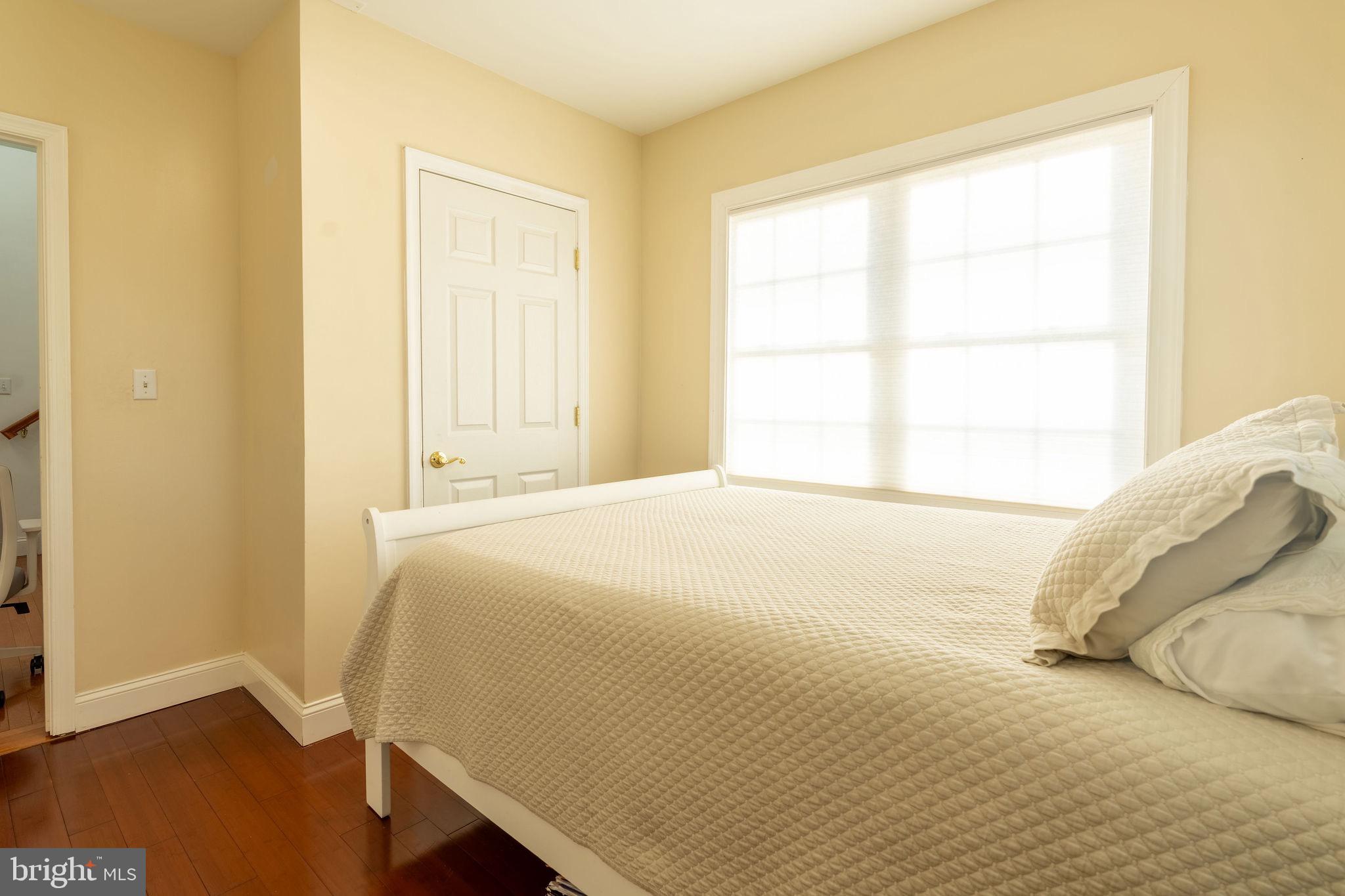 25325 Woodfield Road Damascus, MD 20872 - Photo 53 of 58 a bedroom with a bed and wooden floor