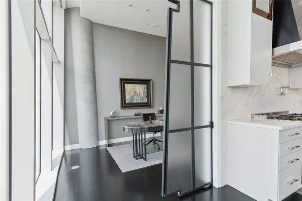 a kitchen with a refrigerator and white cabinets