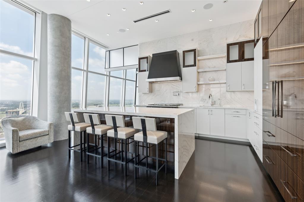 1918 Olive Street, Unit 4202 Dallas, TX 75201 - Photo 15 of 37 a kitchen with stainless steel appliances kitchen island granite countertop a stove a sink and a microwave