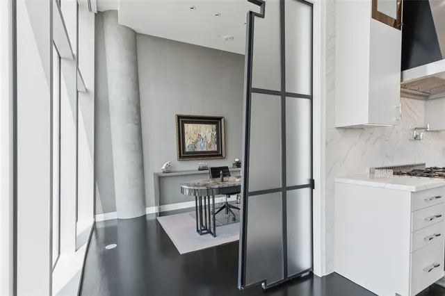 a kitchen with a refrigerator and white cabinets