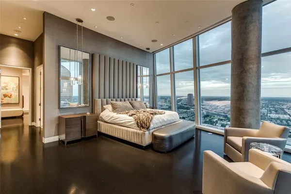 a spacious bedroom with a bed couch and a large window