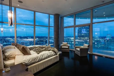 a bedroom with furniture and large windows