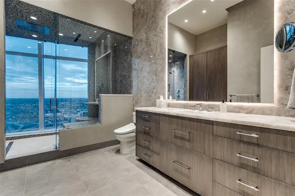 a bathroom with a double vanity sink toilet and shower