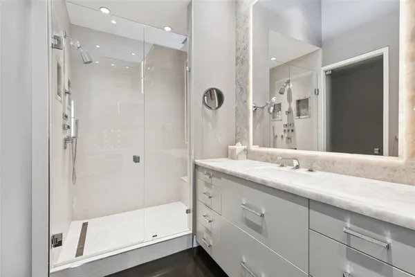 a bathroom with a granite countertop sink mirror and shower