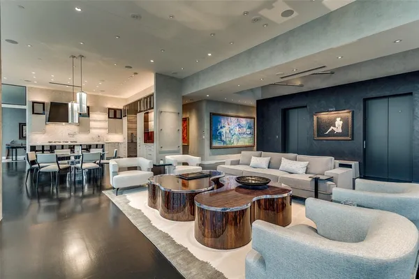a living room with lots of furniture and a view of kitchen