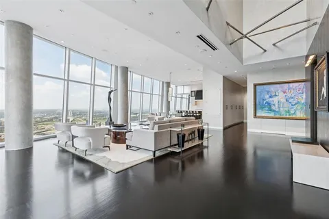 a living room with couches a coffee table and a large window with outer view