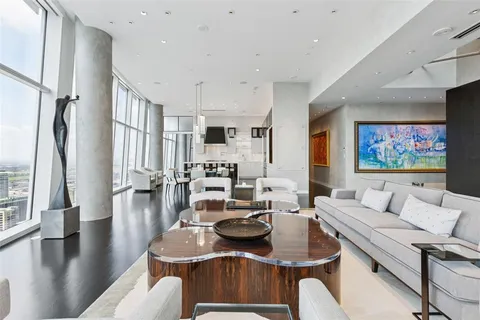 a living room with furniture kitchen view and a large window