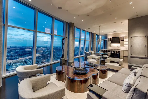 a living room with furniture kitchen view and a large window