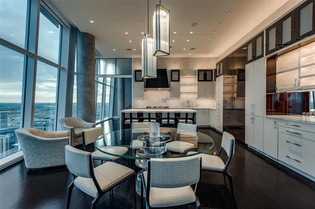 a dining room with furniture kitchen view and large windows