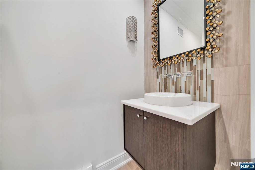 516 Undercliff Avenue Edgewater, NJ 07020 - Photo 12 of 32 a bathroom with a sink a vanity and a mirror