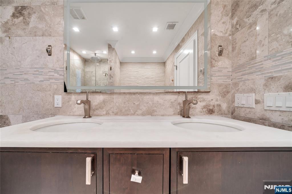 516 Undercliff Avenue Edgewater, NJ 07020 - Photo 18 of 32 a bathroom with a sink and a mirror