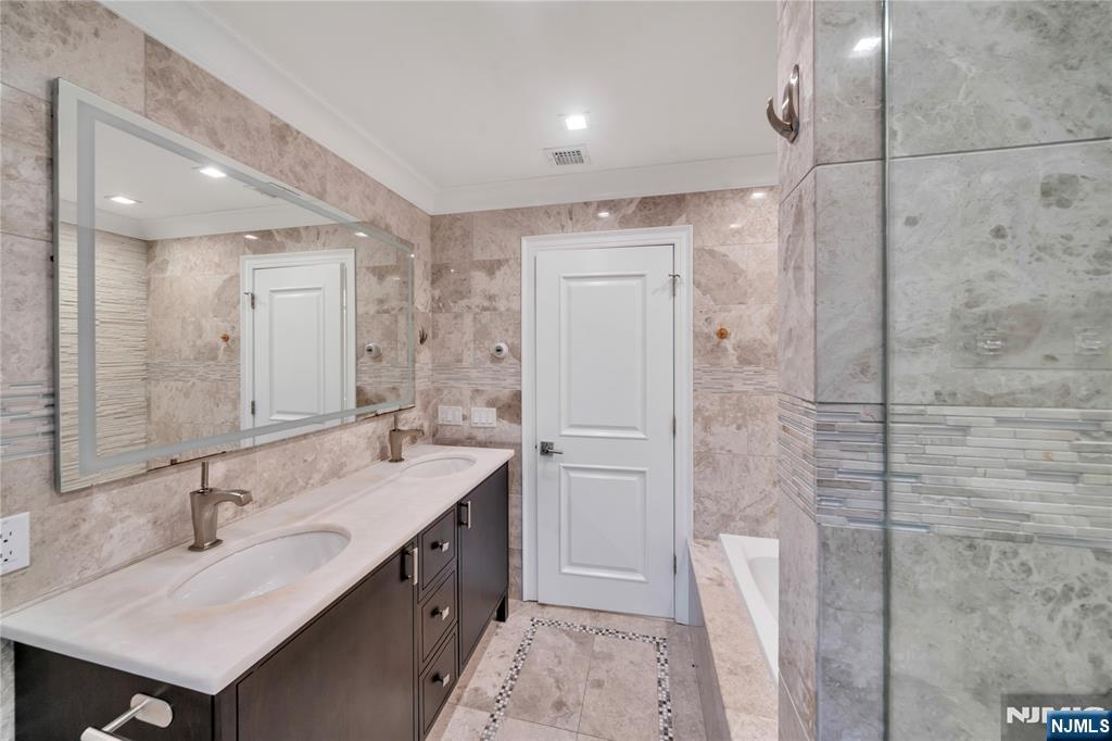 516 Undercliff Avenue Edgewater, NJ 07020 - Photo 19 of 32 a bathroom with a double vanity sink mirror and shower