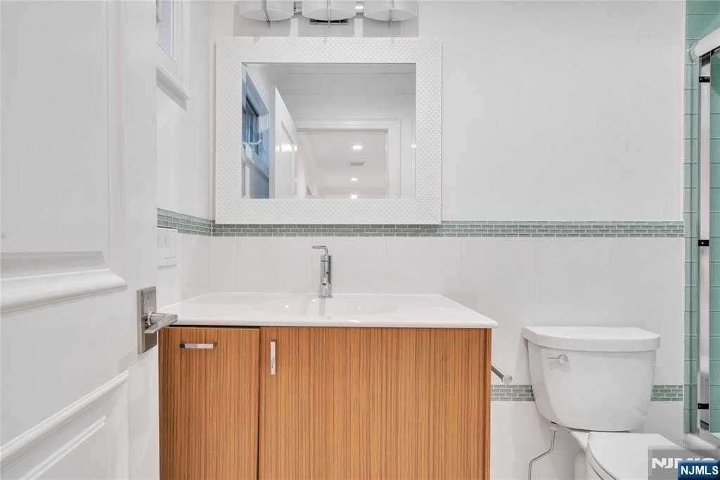 516 Undercliff Avenue Edgewater, NJ 07020 - Photo 25 of 32 a bathroom with a sink a toilet and mirror