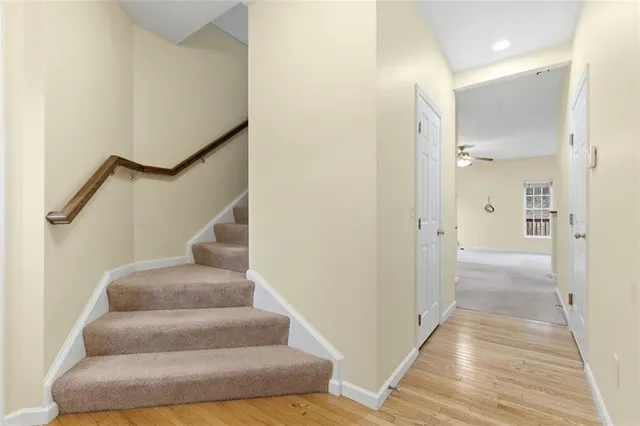 a view of a hallway with wooden floor and staircase
