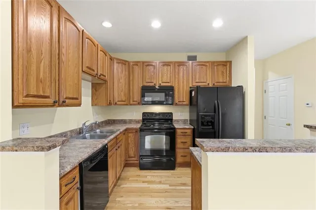 a kitchen with kitchen island granite countertop a stove top oven a sink and a refrigerator