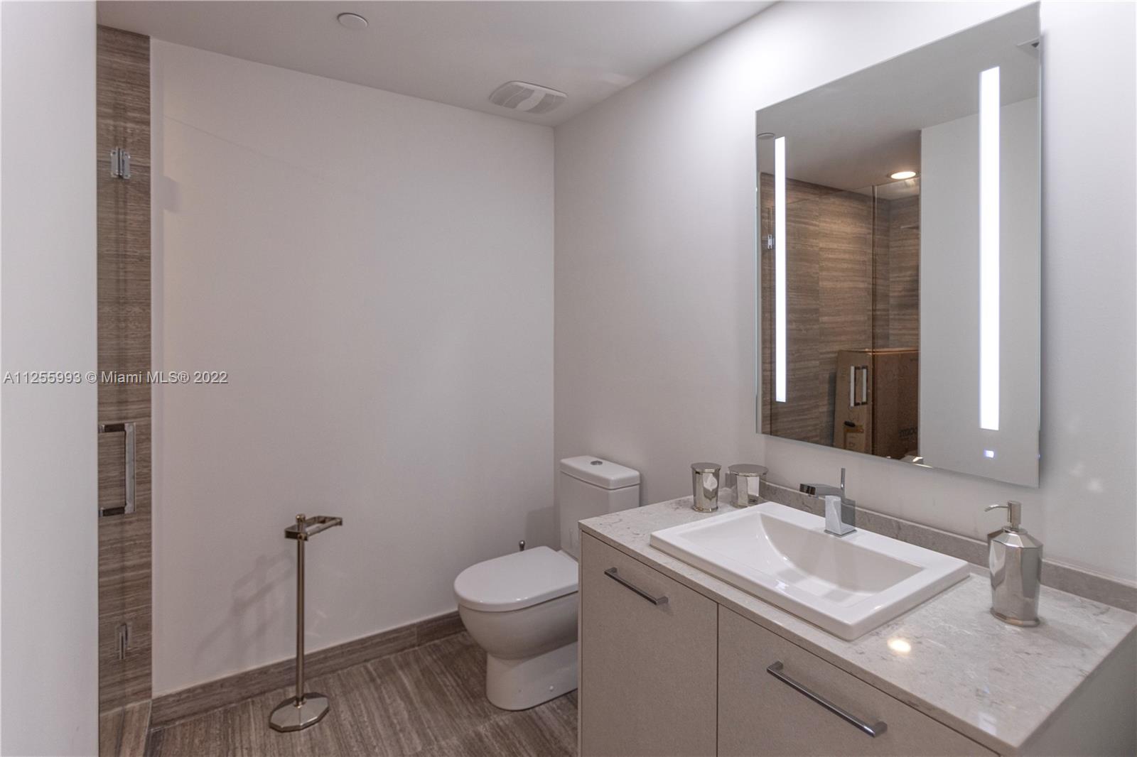 1010 Brickell Avenue, Unit 3003 Miami, FL 33131 - Photo 12 of 32 a bathroom with a sink toilet and vanity