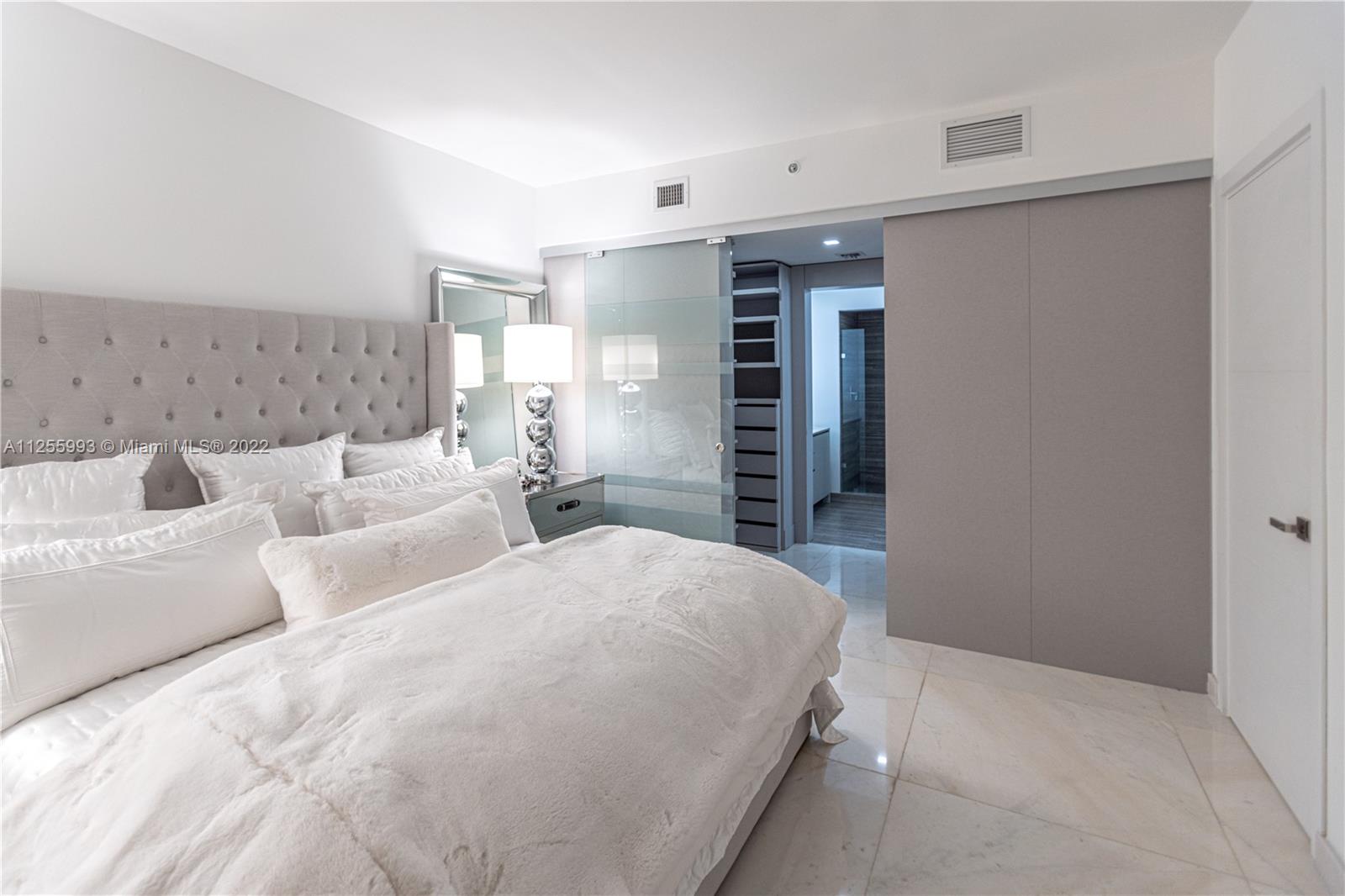 1010 Brickell Avenue, Unit 3003 Miami, FL 33131 - Photo 15 of 32 a spacious bedroom with a bed and a window