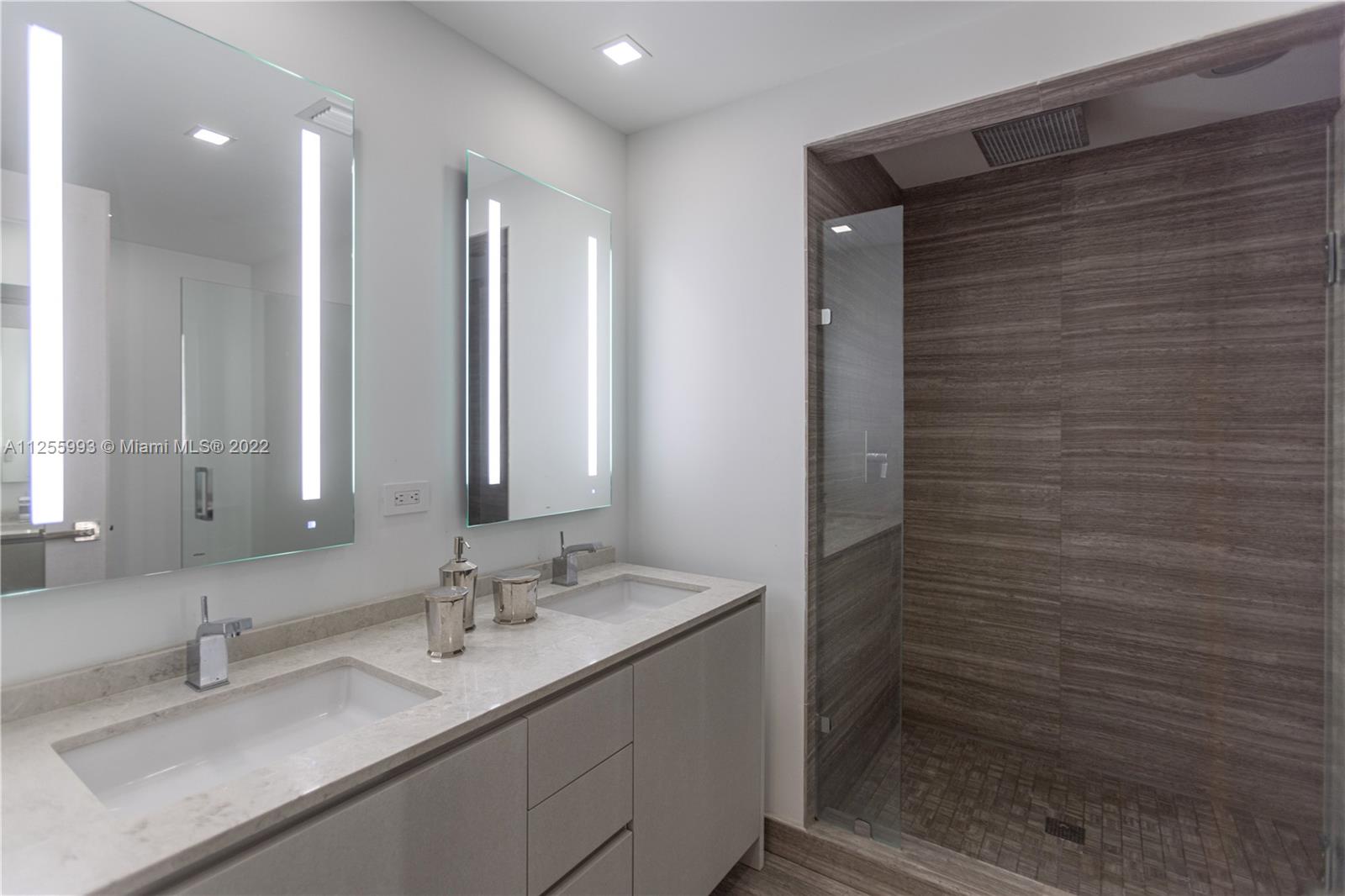 1010 Brickell Avenue, Unit 3003 Miami, FL 33131 - Photo 18 of 32 a bathroom with a granite countertop sink and a mirror