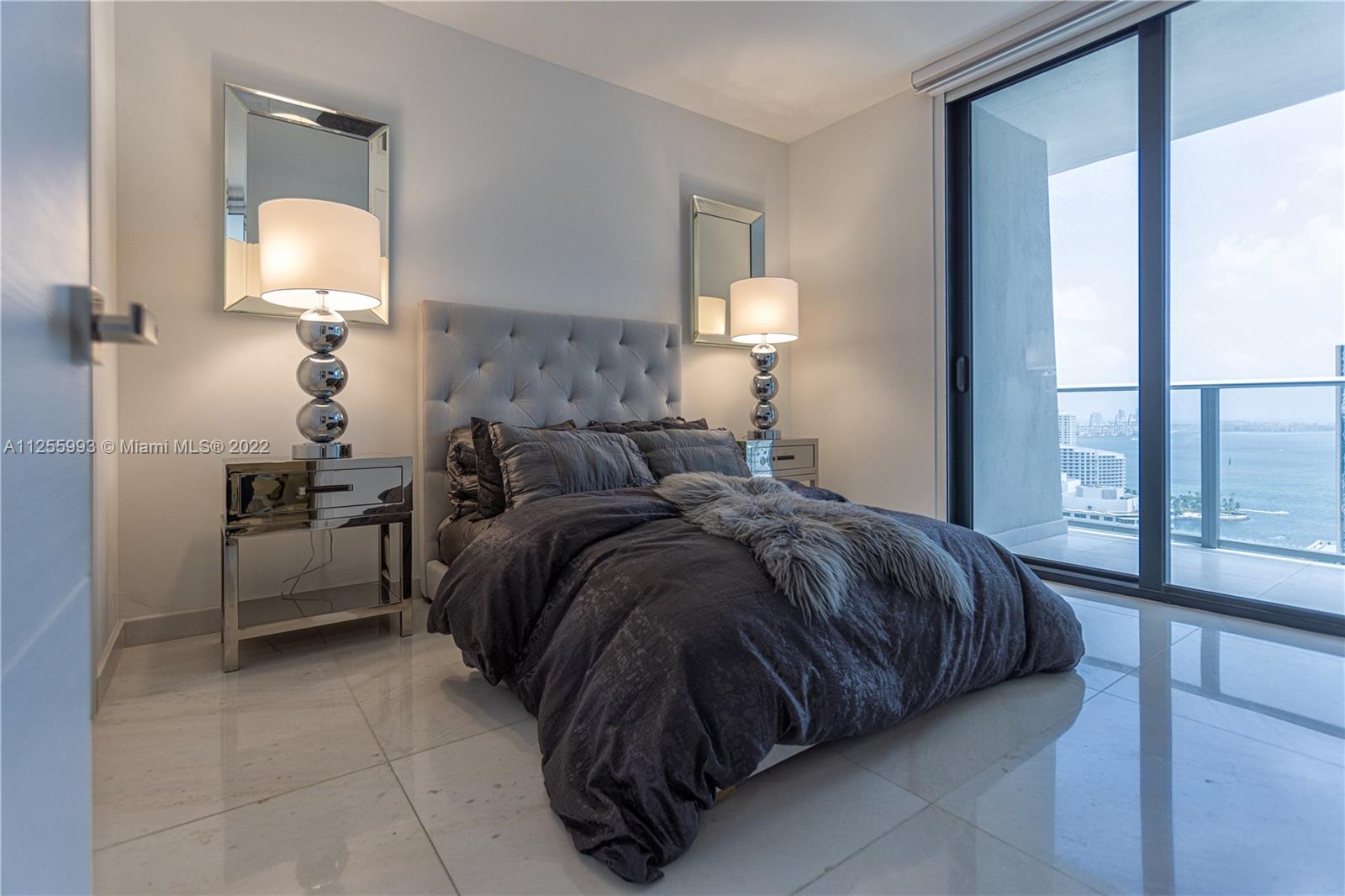 1010 Brickell Avenue, Unit 3003 Miami, FL 33131 - Photo 20 of 32 a bedroom with a bed and a lamp