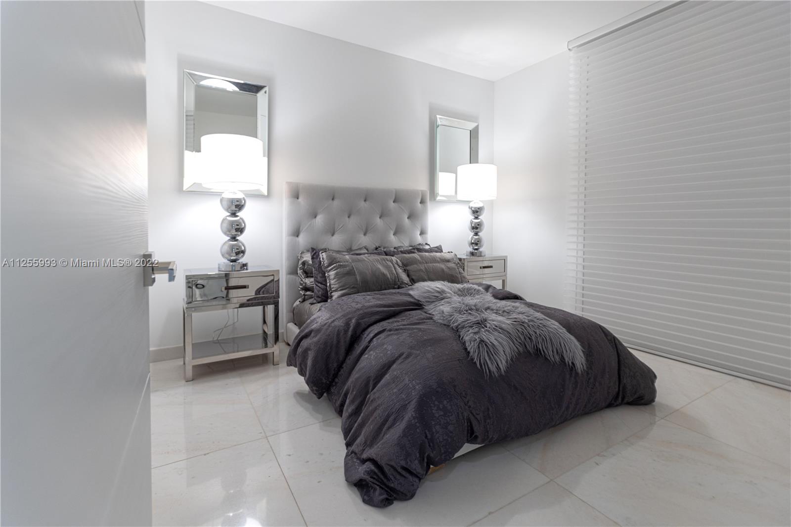 1010 Brickell Avenue, Unit 3003 Miami, FL 33131 - Photo 21 of 32 a bedroom with a bed and a lamp