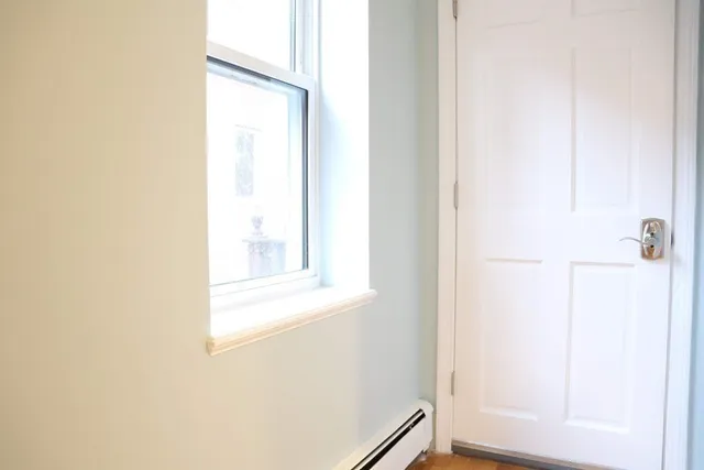 a view of an empty room with wooden floor and cabinet