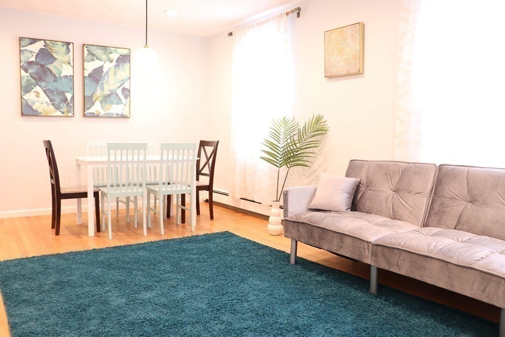 12 Regent Street, Unit 2 Cambridge, MA 02140 - Photo 2 of 42 a living room with furniture and a dining table with garden view