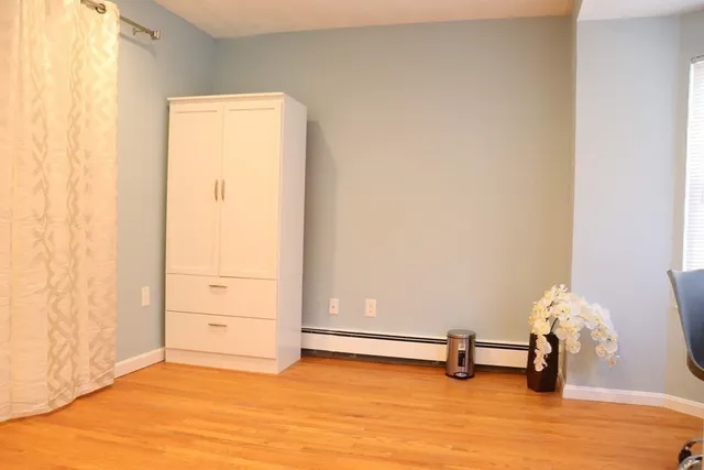 an empty room with wooden floor and a window