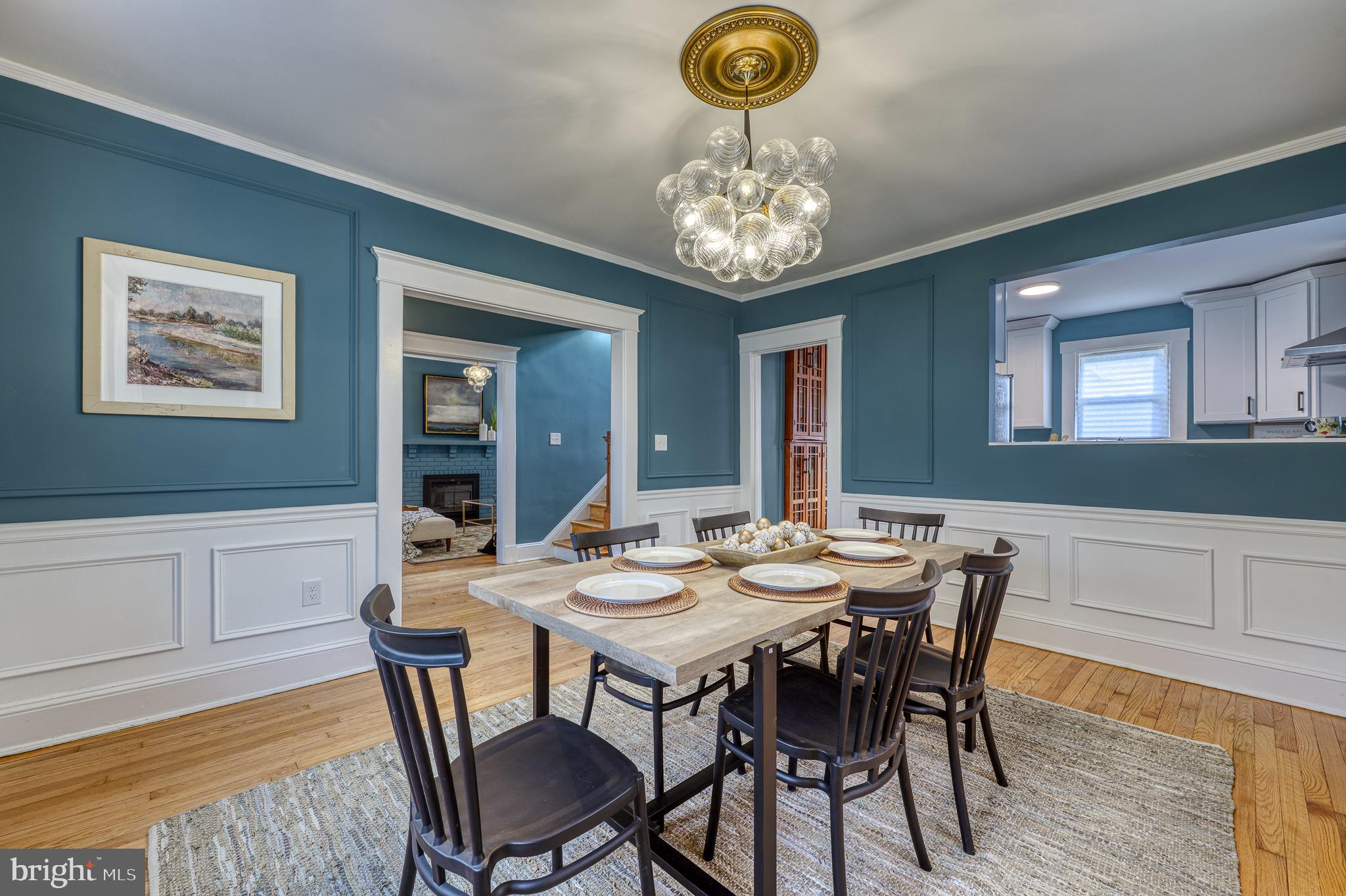 606 Aldershot Road Baltimore, MD 21229 - Photo 15 of 52 a view of a dining room with furniture a chandelier and wooden floor