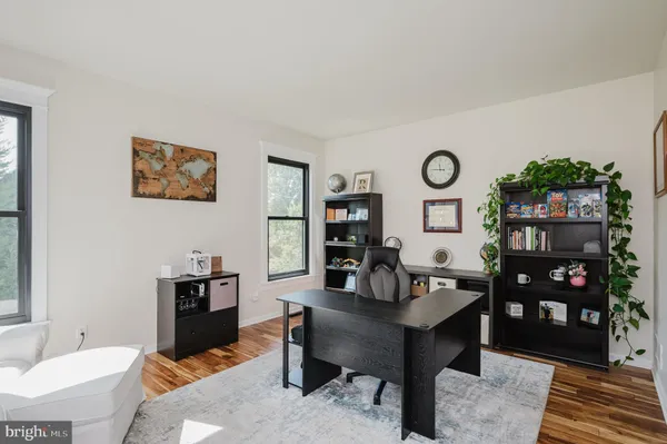 a view of a dining room and livingroom with furniture wooden floor a chandelier