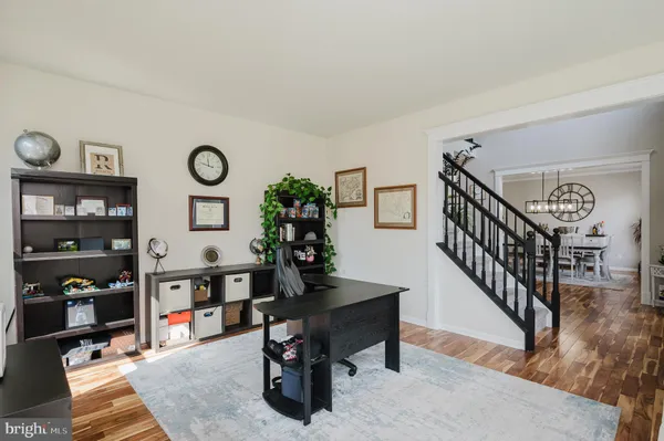 a kitchen with granite countertop stainless steel appliances a sink dishwasher a refrigerator a stove and white cabinets with wooden floor