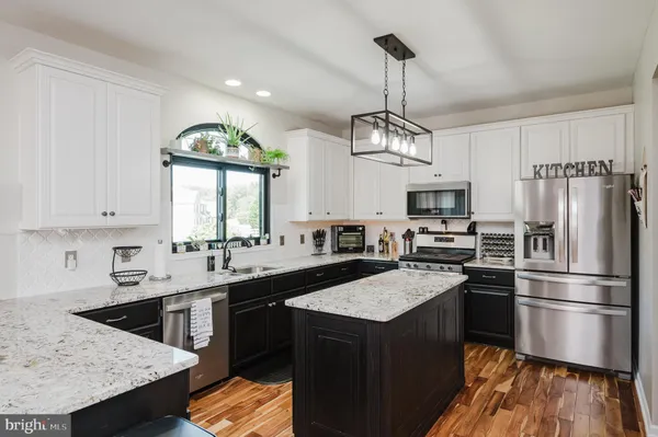 a kitchen with stainless steel appliances granite countertop a sink stove and wooden floor