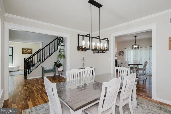 a view of a dining room with furniture a chandelier and wooden floor