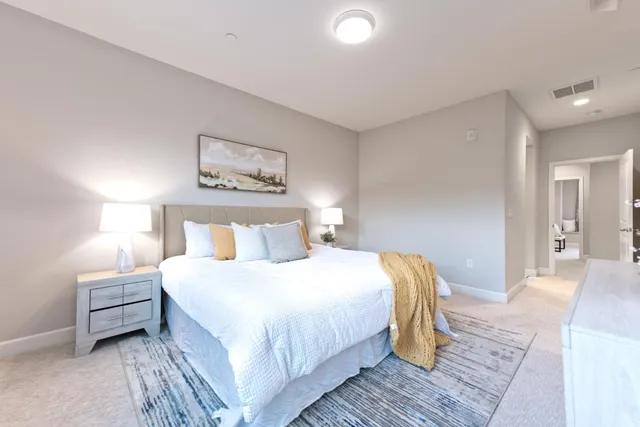 a spacious bedroom with a bed and a mirror