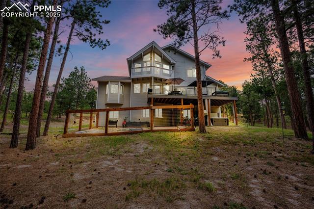 615 Cimarron Road Monument, CO 80132 - Photo 47 of 50 Back of property at dusk with a deck and a patio area