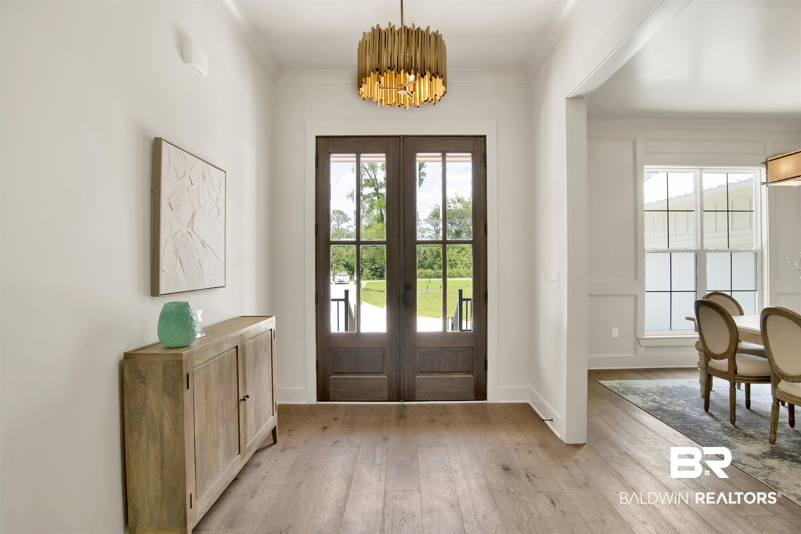 9275 Clarke Ridge Road Foley, AL 36535 - Photo 7 of 43 Entrance foyer featuring french doors, light wood-type flooring, a chandelier, baseboards, and ornamental molding
