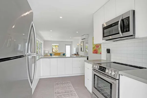 a kitchen with stainless steel appliances granite countertop a stove a refrigerator and a microwave