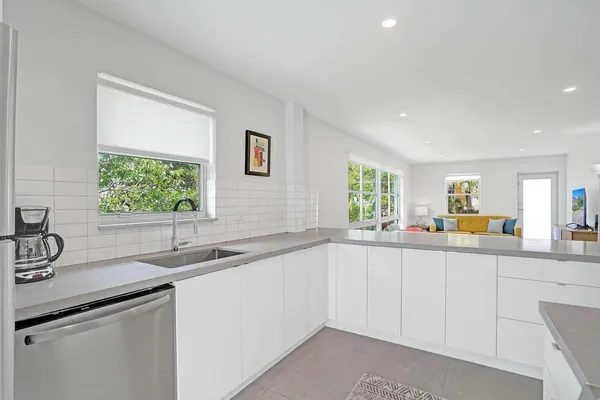 a kitchen with sink attached with living room
