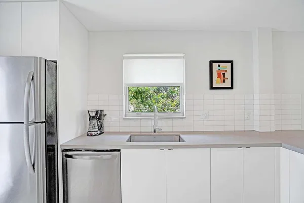 a kitchen with stainless steel appliances a sink and a refrigerator