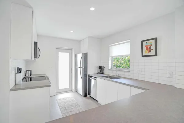 a kitchen with stainless steel appliances granite countertop a sink and a refrigerator