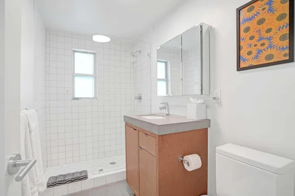 a bathroom with a sink a toilet and shower