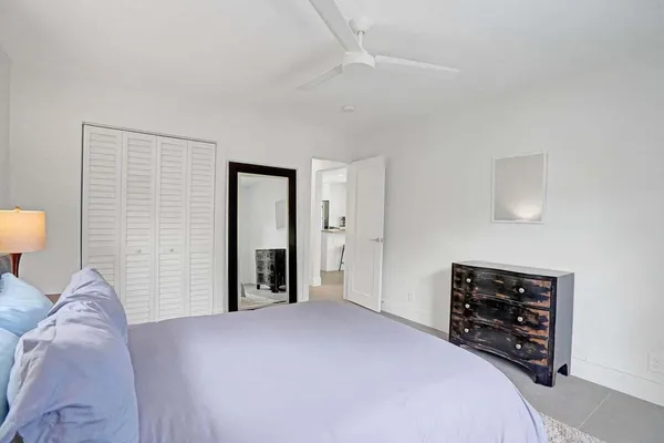 a bedroom with a bed and a lamp on dresser